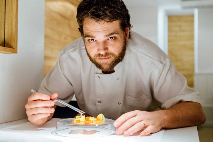 El chef, con un plato de atún escabechado, con puntas de espárrago blanco y raiford