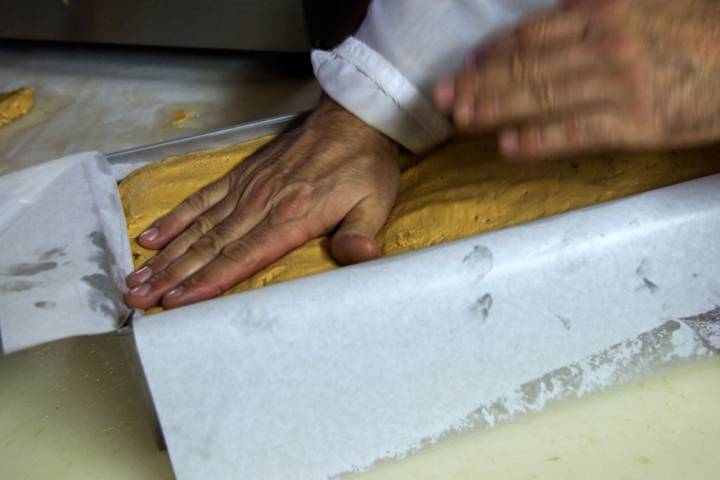 Un maestro turronero da palmadas a la masa. Después reposa dos días.