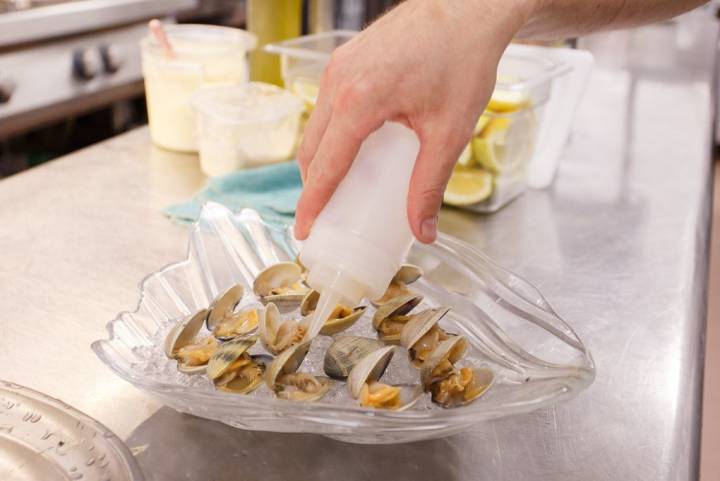 Preparando una de las especialidades de la casa: tellinas con aceite.