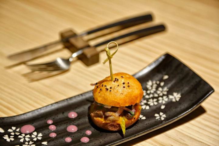 Su chicharrón de cerdo presentado en un bao chino.