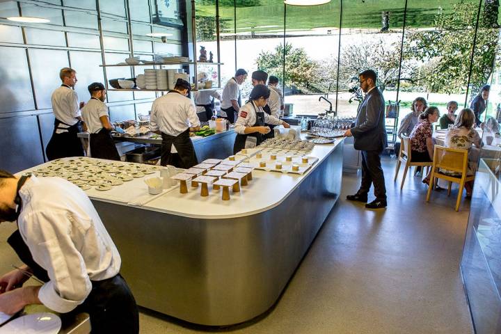 Una mesa comparte espacio con la cocina de platos fríos y tiene vistas del jardín y huerto.