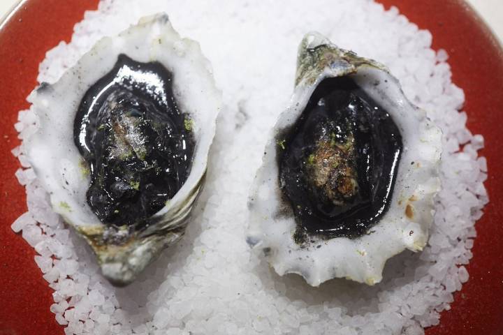 Plato de ostras sopleteadas y tinta de calamar del restaurante Hetta, en Barcelona.