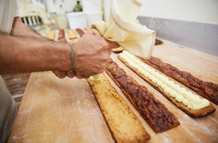 Rellenando de crema pastelera las famosas cocas de crema de la casa.