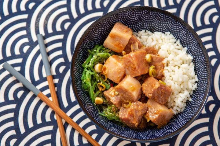 Un poke bowl de atún picante junto a unos palillos chinos listo para comer.