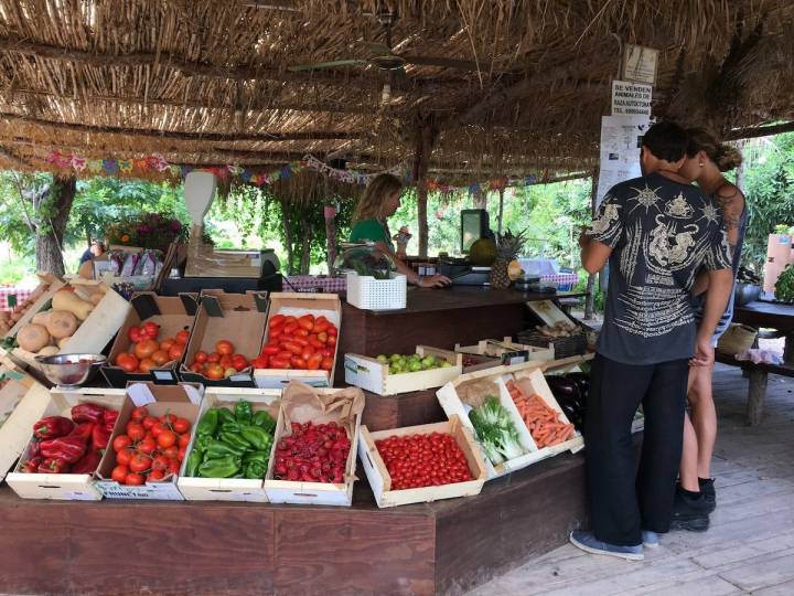 Unos padres aprovechan para comprar frutas y verduras en la tienda de la granja.