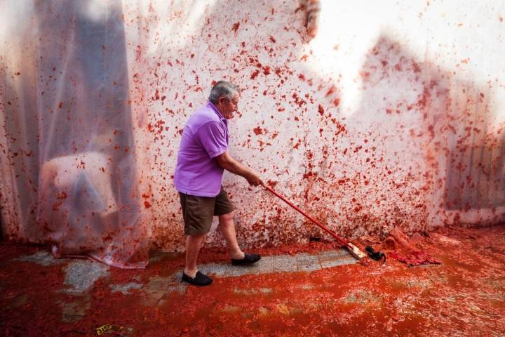 Es hora de la limpieza. Los vecinos barren las calles teñidos de rojo.