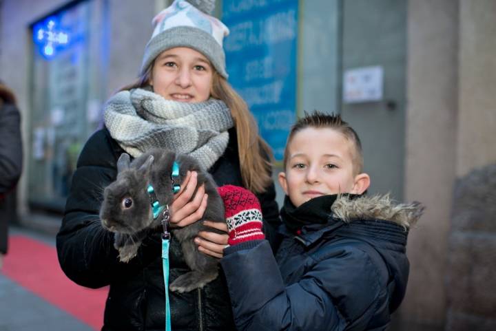 Dos hermanos con el conejo Bunny a las puertas de la iglesia de San Antón.