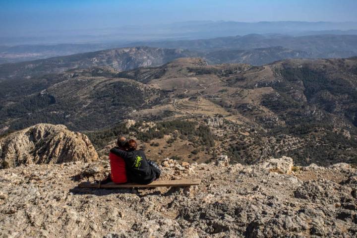 Una pareja sentada en la cima del Penyagolosa.