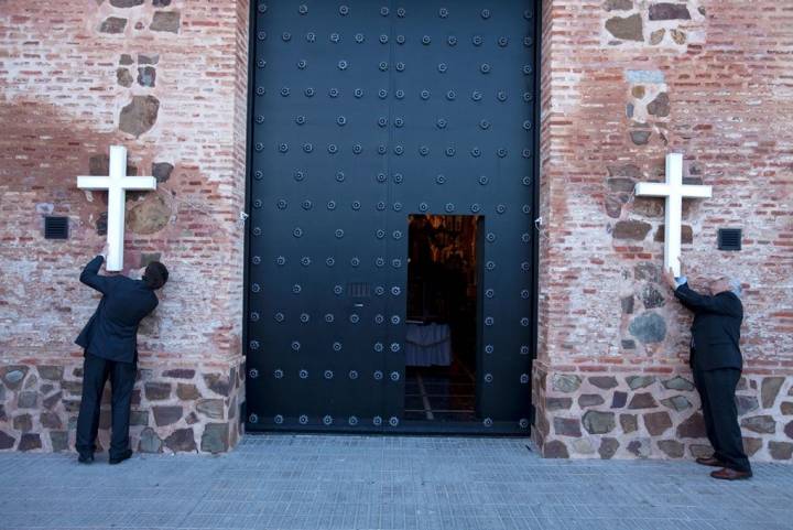 Miembros de la Hermandad en Calzada de Calatrava colocan cruces en la fachada de la ermita.